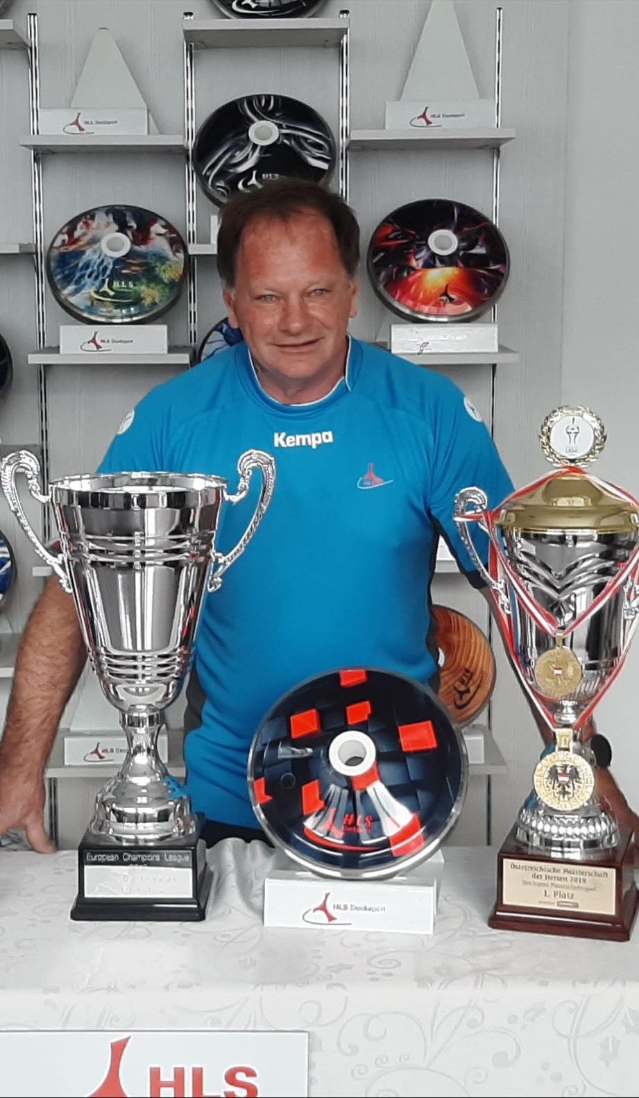 Werner Hutter im HLS-Ausstellungsraum, links der Champions-League-Pokal, rechts der Pokal der Österreichischen Meisterschaft 2019